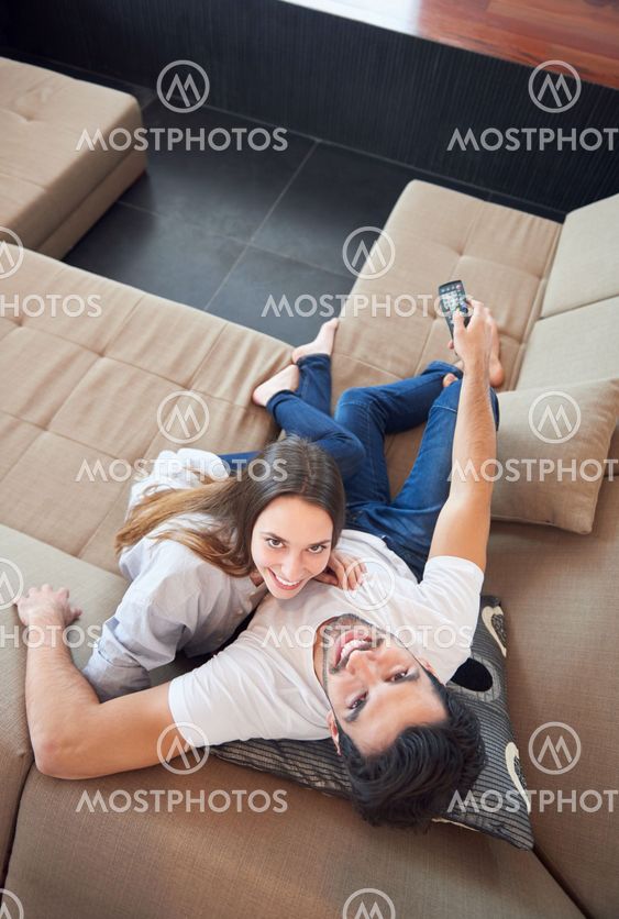 young couple watching tv at home