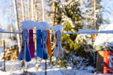 snow-covered clothespins on clothesline close-up