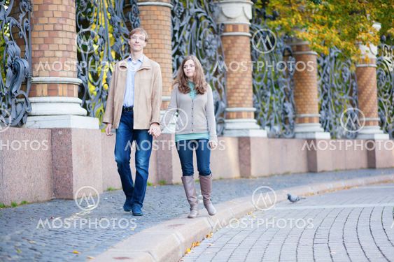 Couple walking by the beautiful grill of Mikhailovsky (Michael) garden of Saint-Petersburg