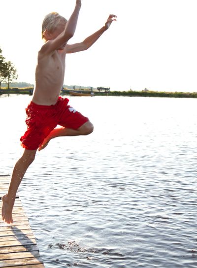 Pojke hoppar från brygga