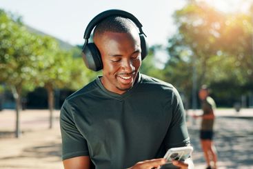 Outdoor, black man and music with smartphone for...