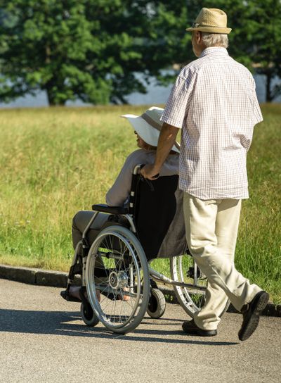 Senior husband pushing wife's wheelchair