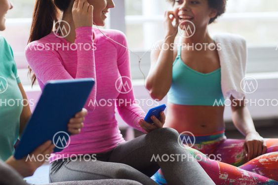 close up of happy women listening to music in gym
