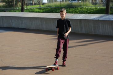Handsome teenager standing with skateboard. Adolescent...