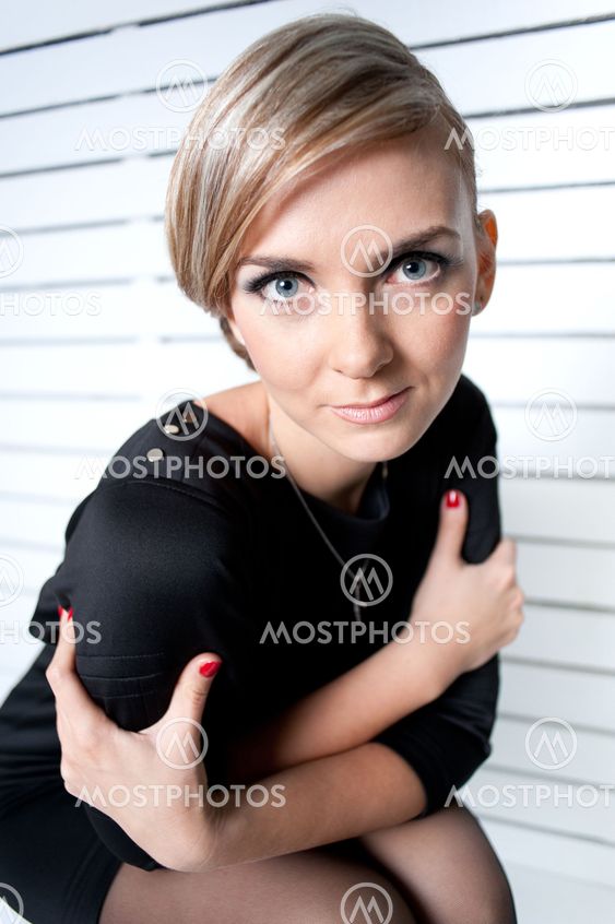 The beautiful girl embraces herself arms
