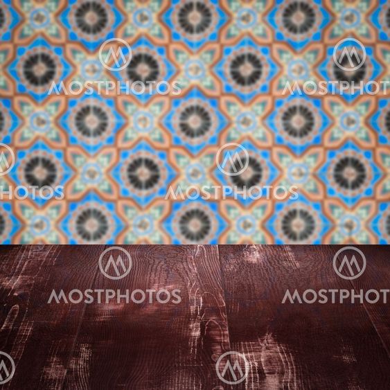 Wood table top and blur vintage ceramic tile pattern wall