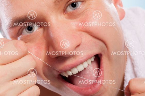 Young man cleaning her white teeth with dental floss