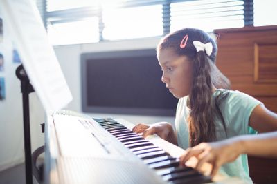 Concentrated elementary girl practicing piano