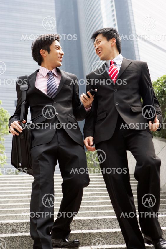 Two Chinese Businessmen Having Discussion Walking Down Steps Outside Office