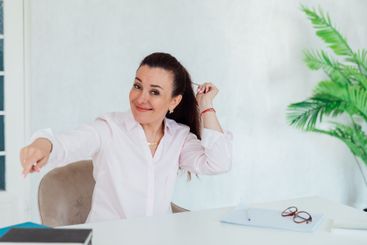 Brunette businesswoman sitting at desk in office and...