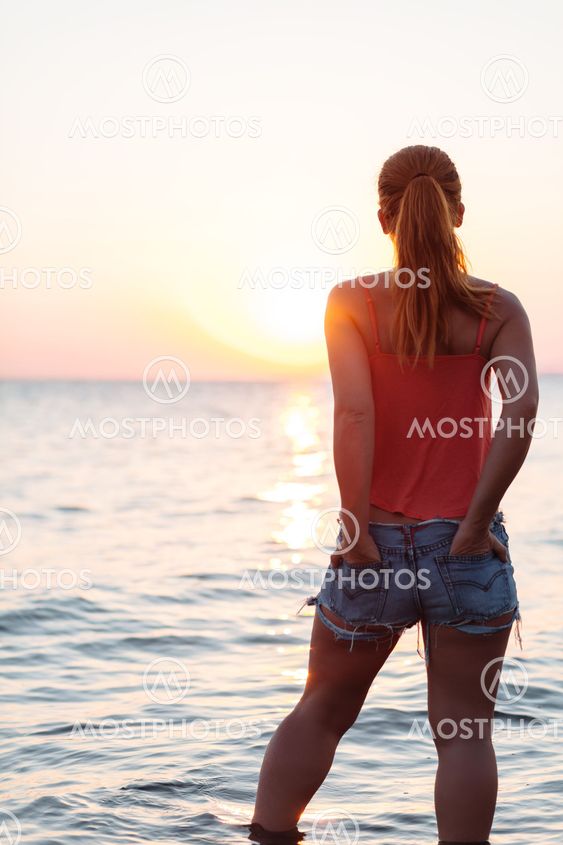 Young woman enjoying sea and sunset