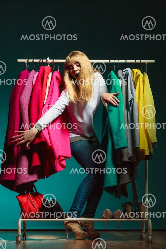 Woman sneaking among clothes in mall or wardrobe.