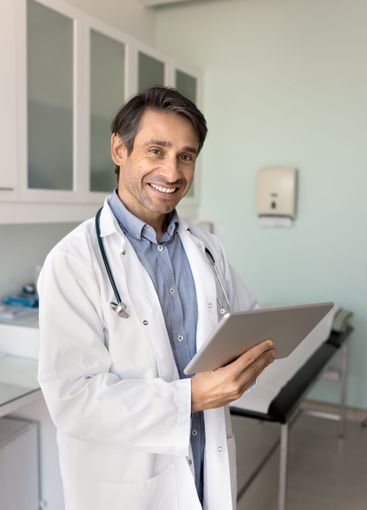 Cheerful Hispanic male doctor analyzing electronic...
