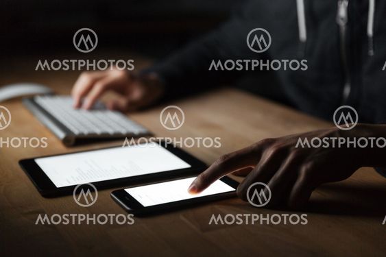 Man using blank screen and cell phone on the table