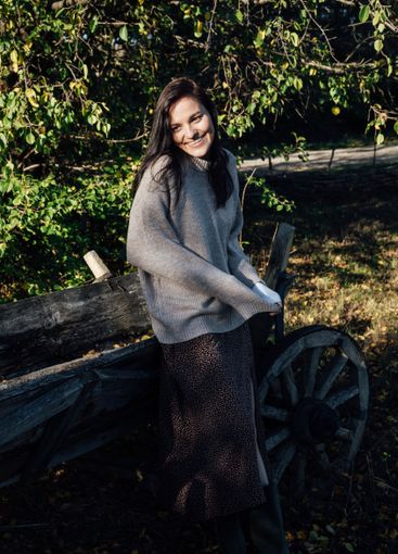 Beautiful brunette woman in coat at wooden cart