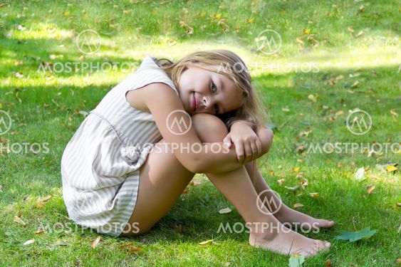 Cute girl sitting on green grass