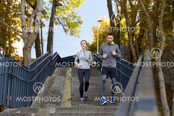 happy couple running downstairs in city