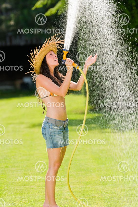 Summer garden woman play with water hose