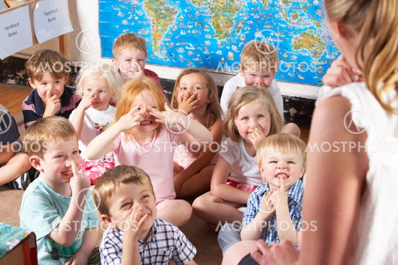 Montessori/Pre-School Class Listening to Teacher on Carpet