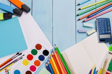 Colorful art supplies and stationery arranged on a...