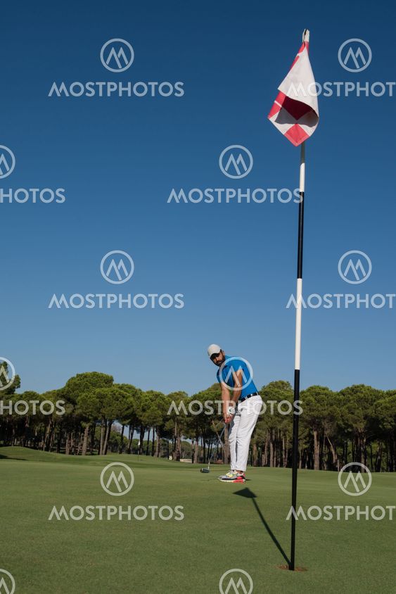 golf player hitting shot at sunny day