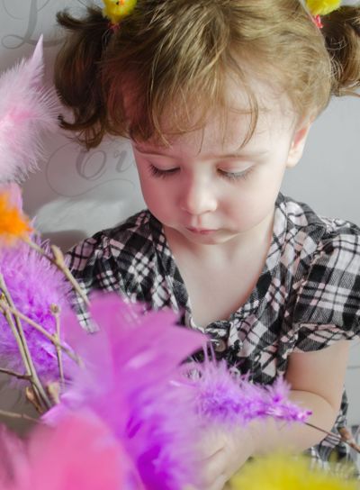 Flicka som fascineras av färglatt påskris.