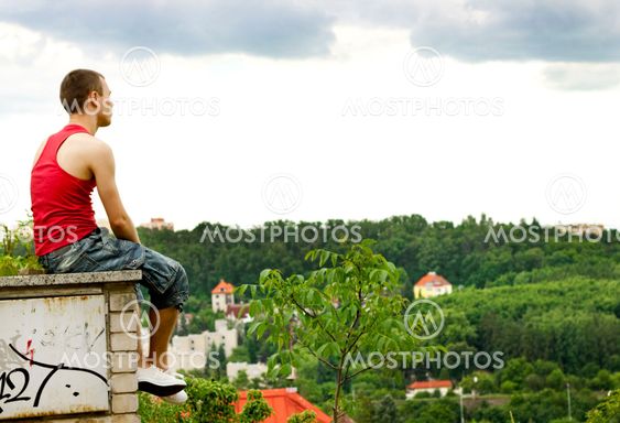 A guy sitting on a fence