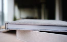 A photo book in a grey cloth cover lies on the box. the...