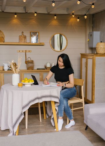 Young woman works from home via video link with documents