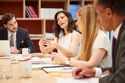 Four people at a business boardroom meeting