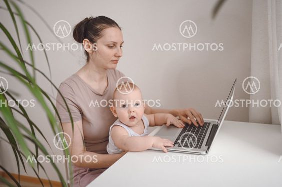 Young mother work studying from home with laptop...