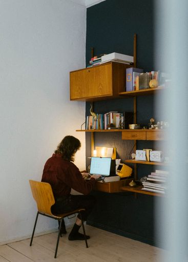 Rear view of male freelancer working on laptop at home