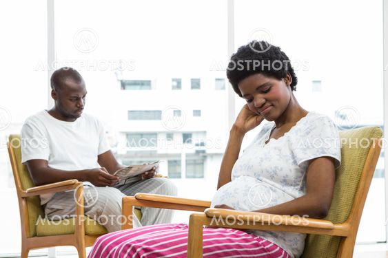Pregnant couple sitting on chair