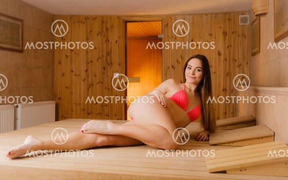 Woman relaxing in spa sauna.