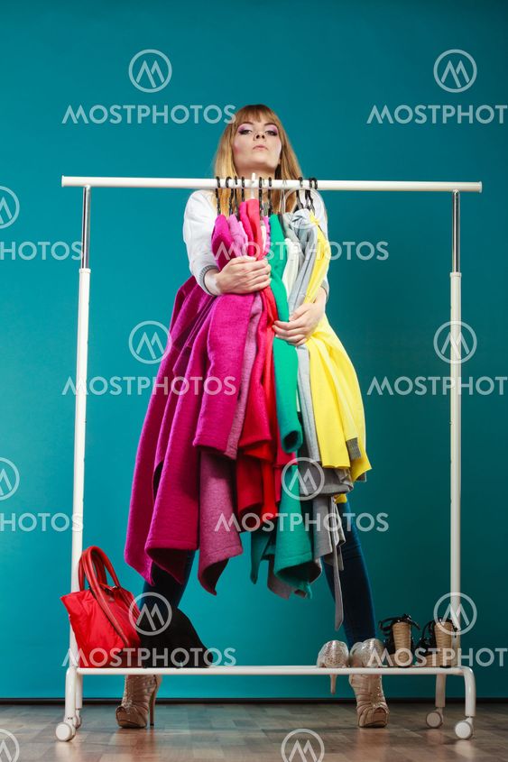 Funny woman taking all clothes in mall or wardrobe