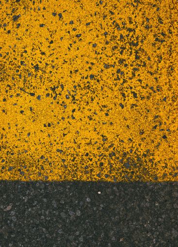 Yellow paint road marking on asphalt highway surface,...