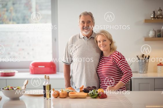 Smiling senior couple standing together in kitchen