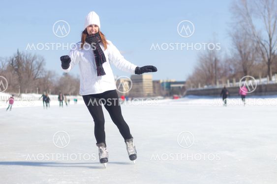 Attractive young woman ice skating during winter
