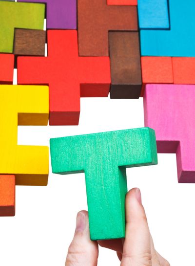 putting T-shaped block in multicoloured puzzle
