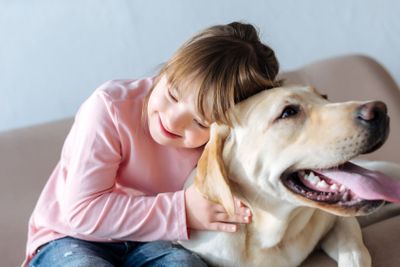 Happy child with down syndrome and Labrador retriever dog...