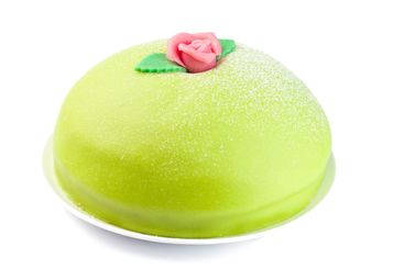 Swedish dessert Princess cake on a white plate, isolated...
