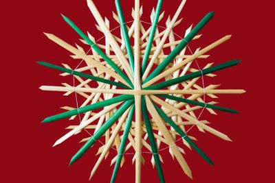 Straw star Christmas decoration over red