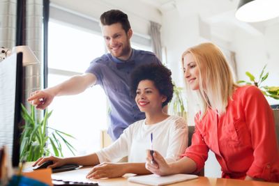 happy creative team with computer in office
