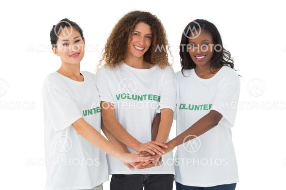 Team of happy volunteers putting hands together