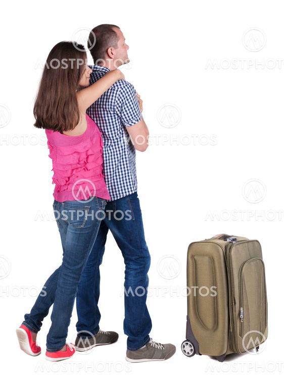 Back view of young couple traveling with suitcas .