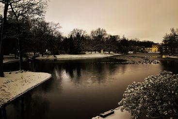 Winter evening landscape of a snowy park with a calm...