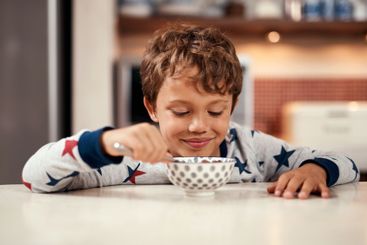 Happy, breakfast and boy with cereal, kitchen and joy...