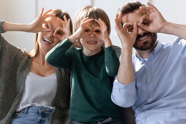 Portrait of happy parents with kid make funny faces