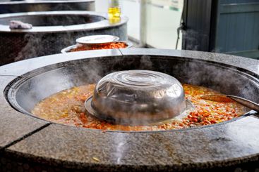 cooking traditional uzbek dish rice pilaf with meat lamb...