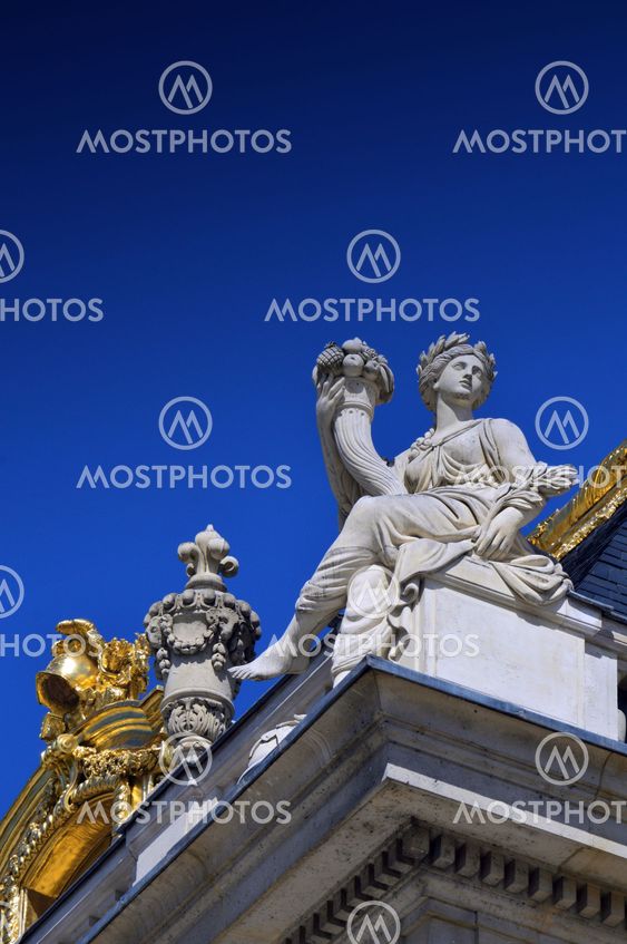 Beautiful roof details with golden ornaments and statues of Palace of Versailles